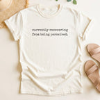 Ivory t-shirt with text 'currently recovering from being perceived' on a light background
