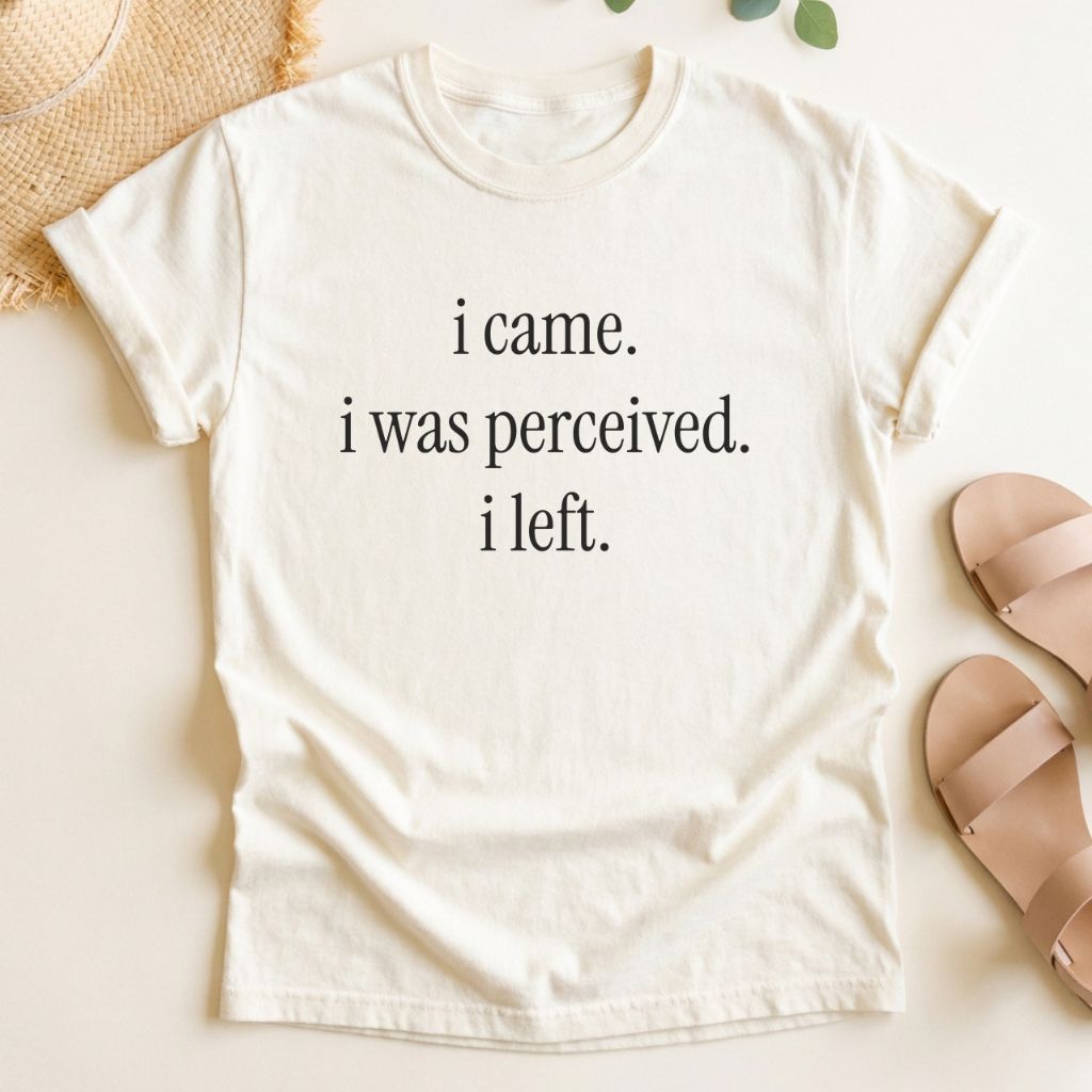 Ivory t-shirt with text 'i came. i was perceived. i left.' on a light background