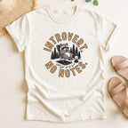 Ivory  t-shirt with a raccoon graphic and 'Introvert No Notes' text on a light surface.